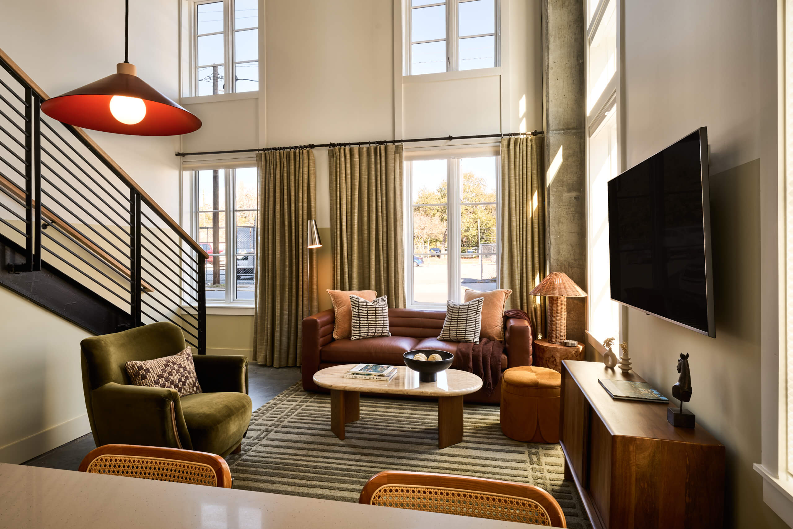 4-Bedroom Loft Suite at The Ann Savannah — double-height ceilings, staircase, sage walls, cognac leather