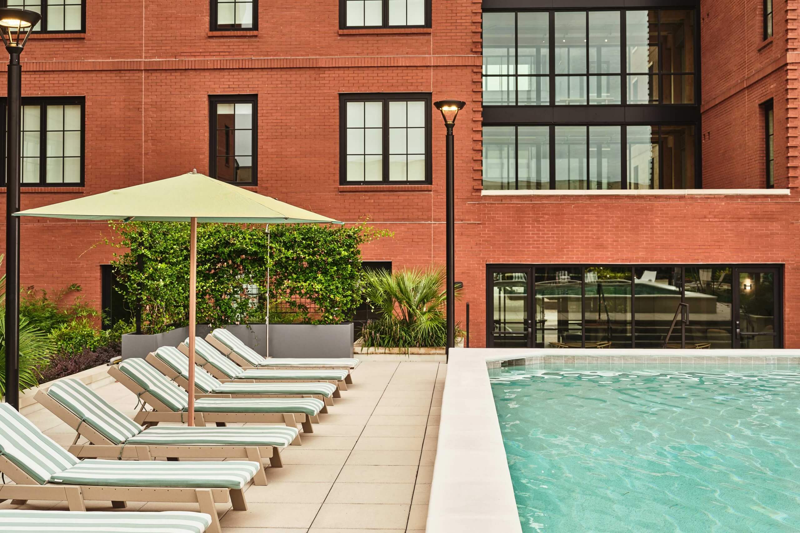 View of pool and lounge chairs with umbrella
