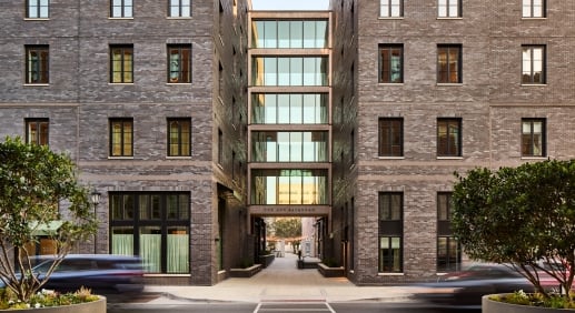The Ann Savannah exterior — twin brick wings joined by a glass breezeway, viewed from Ann Street