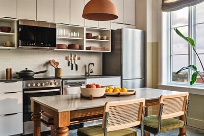 Bright modern kitchen with white cabinetry and wood dining table at The Ann Savannah